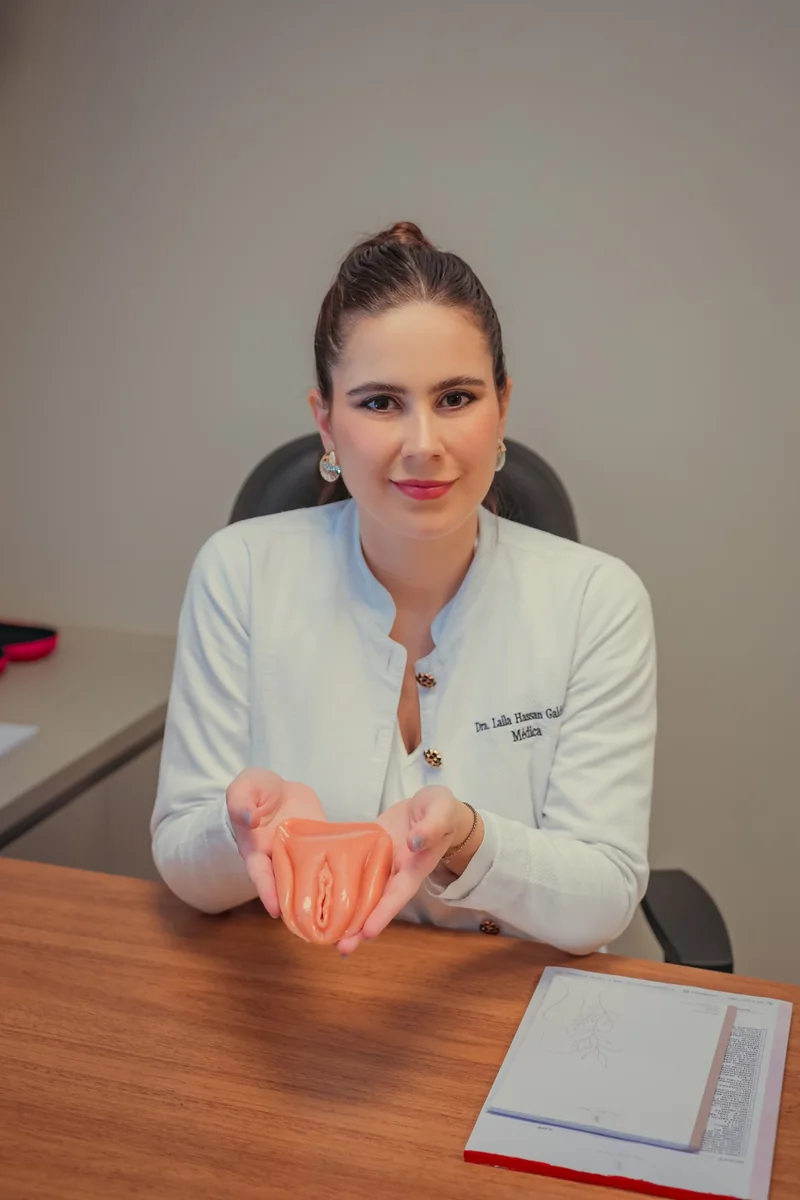Dra. Laila Hassan à mesa, segurando um modelo anatômico do sistema reprodutor.